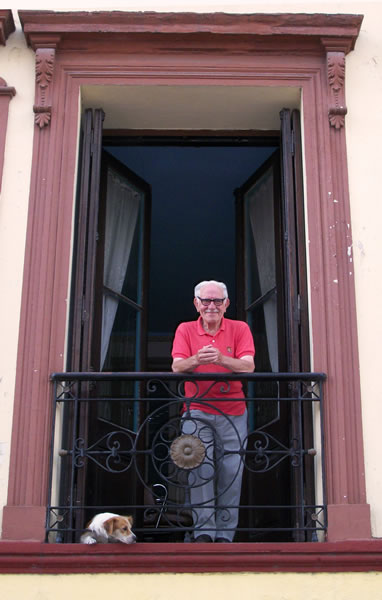 A resident and senior citizen in San Telmo, Buenos Aires admiring the view from his French balcony. 