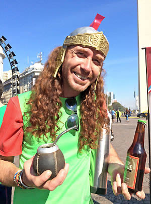 A red-headed man in Buenos Aires holds a gourd for mate tea and a beer