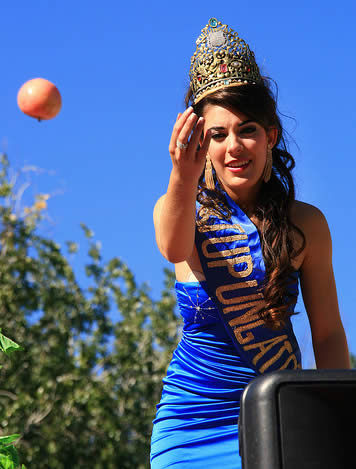 One of Mendoza's Vendimia Queens launches an apple from her float.