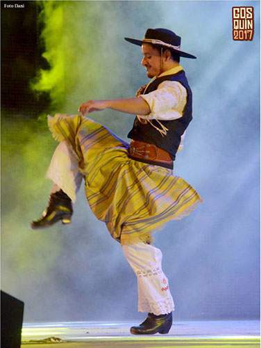 A man in a traditional Argentine folk dance costume preforms fancy footwork on stage at the Cosquin Folklore Festival in Argentina 