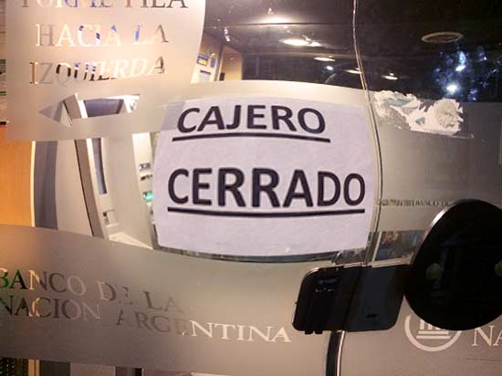 A picture of a sign taped to a bank door that says 'cajero cerrado' ('ATM closed'), which is a common sight at ATM's in Argentina 