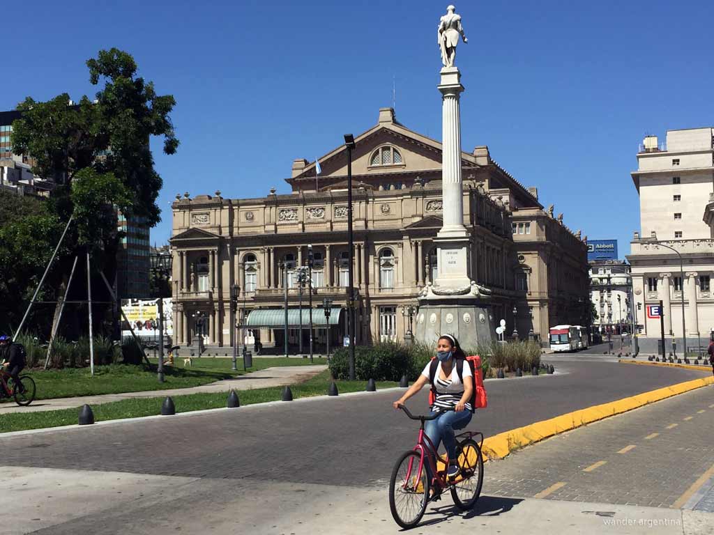A woman on a bicycle in front of the Colon Theater in Buenos Aires