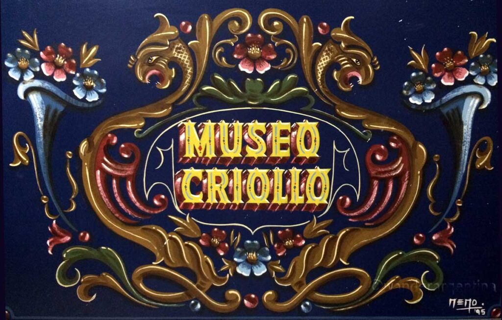 Handpainted sign in the fileteado style that says 'Museo Criollo' 