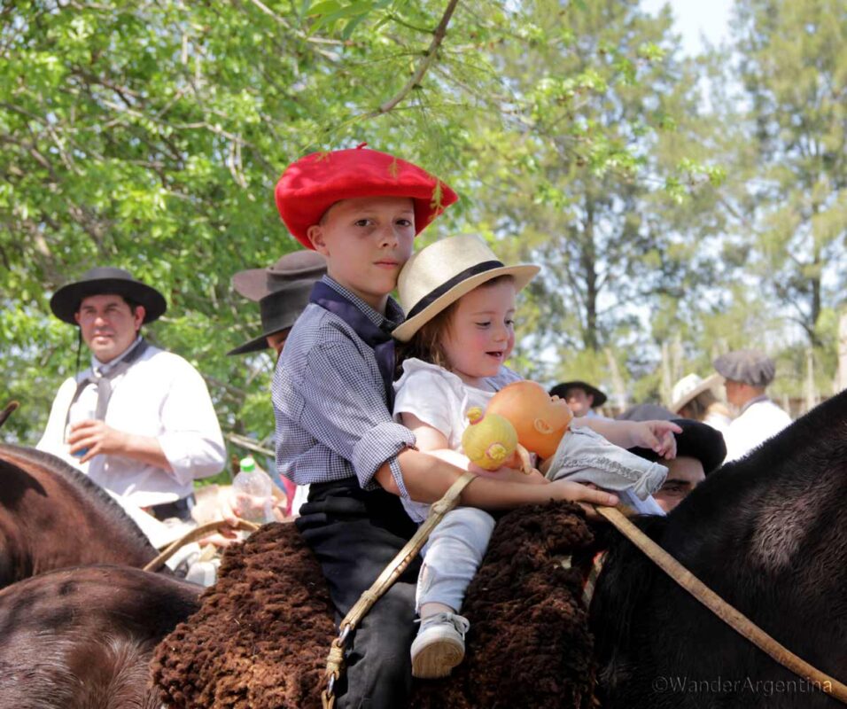 Gauchos in Argentina start riding horses young, although this little girl didn't want to give up her dolly. 